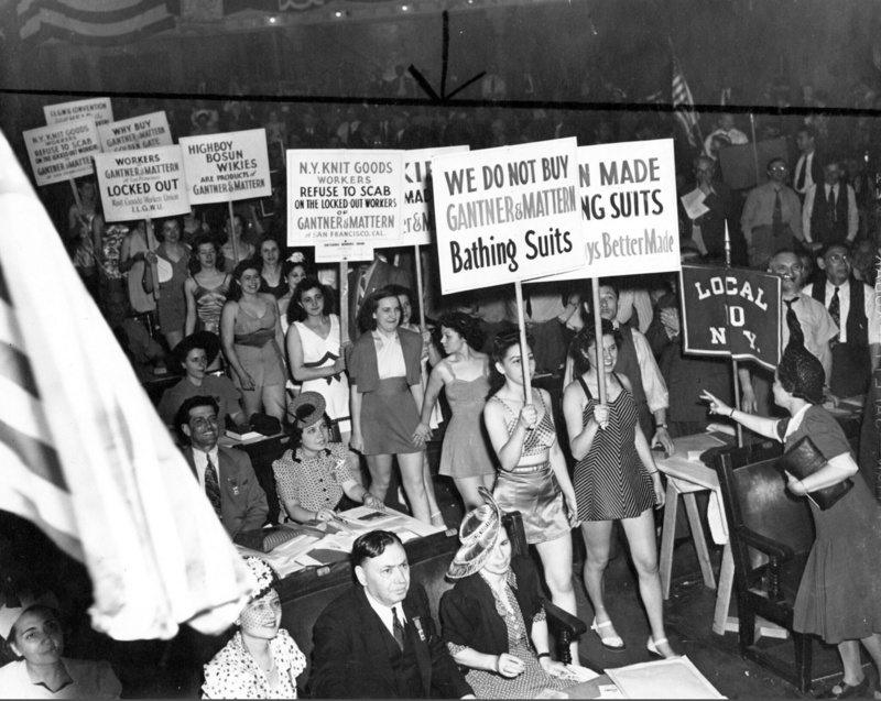 Women in bathing suits march down an aisle at a union convention, in support of the strike against Gantner and Mattern.