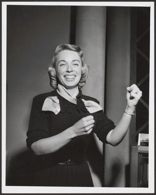 Dr. Brothers puts up her fists after winning The $64,000 Question. December, 1955.